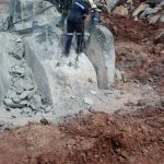 drilling and pouring of rock breaking chemical on massive boulders on a mine - very challenging formation boulder